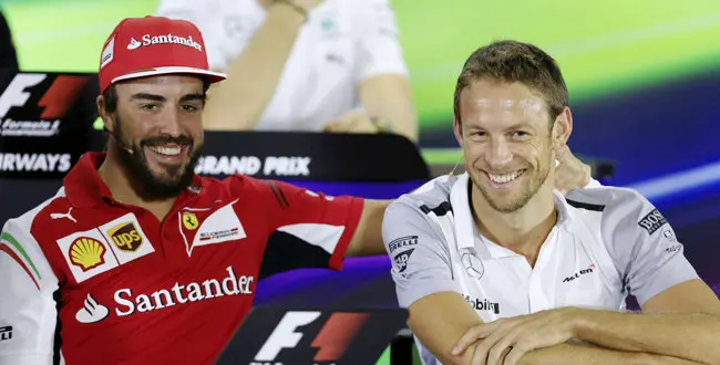 Ferrari driver Fernando Alonso and McLaren Mercedes driver Jenson Button share a lighter moment during a news conference at the Yas Marina racetrack in Abu Dhabi, United Arab Emirates, Thursday, Nov. 20, 2014.